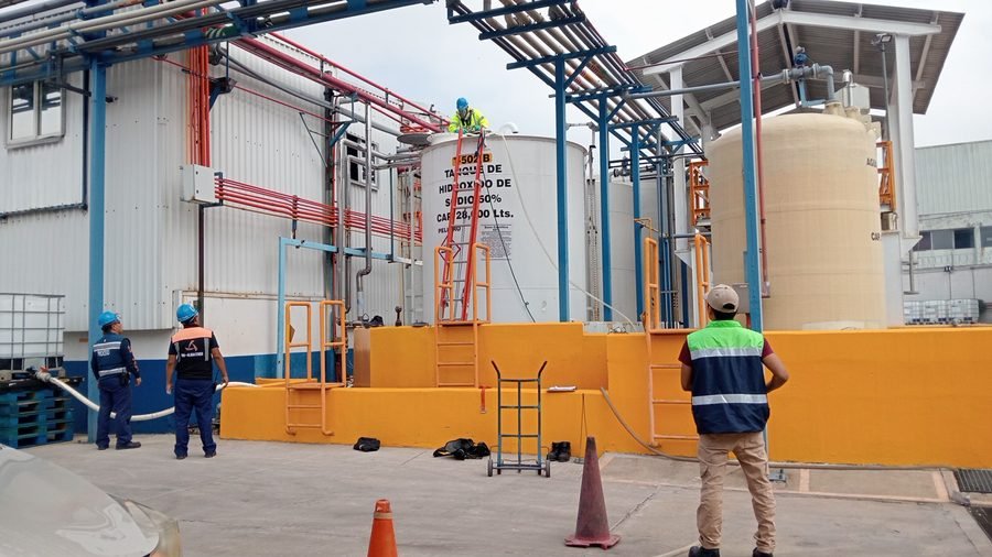 Inspección de seguridad industrial en planta con trabajadores usando casco y chaleco reflejante