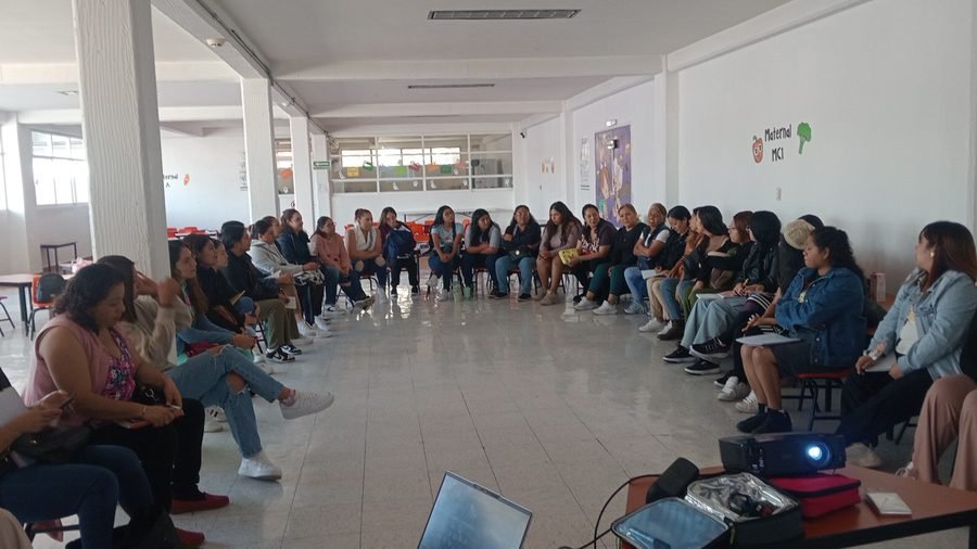 Grupo numeroso sentado en semicírculo durante una sesión de capacitación