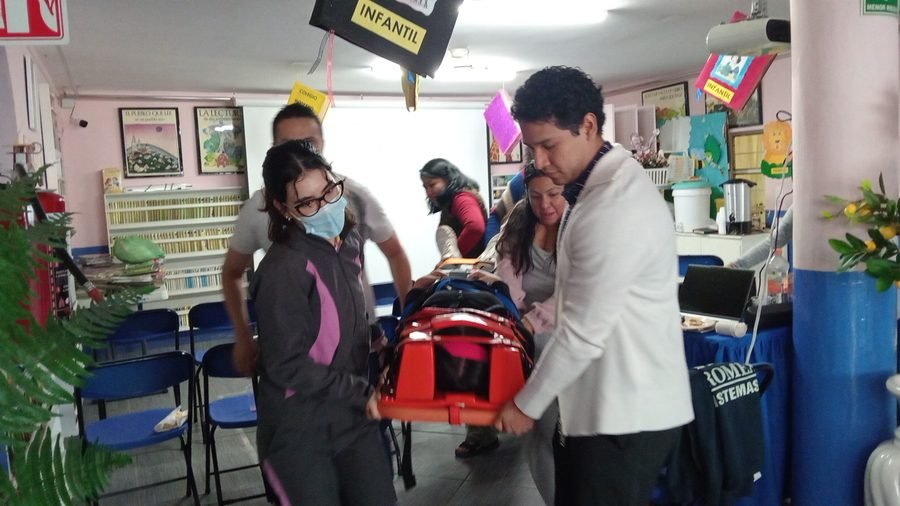 Grupo realizando un simulacro de evacuación con camilla de rescate